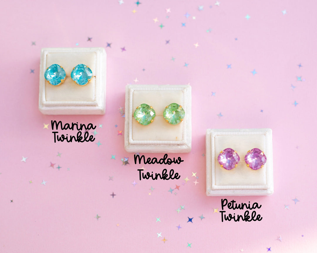 3 pairs of stud earrings on a pink background.