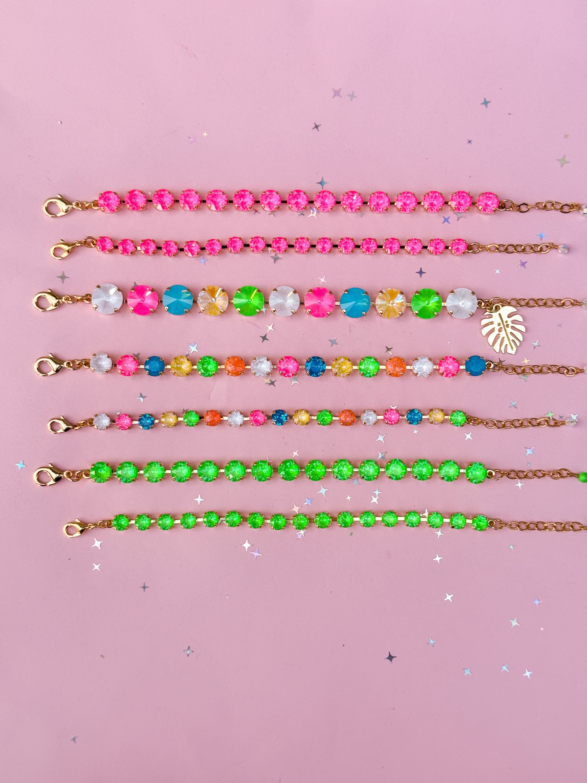 colorful laid out bracelets that are neon colors on a pink background