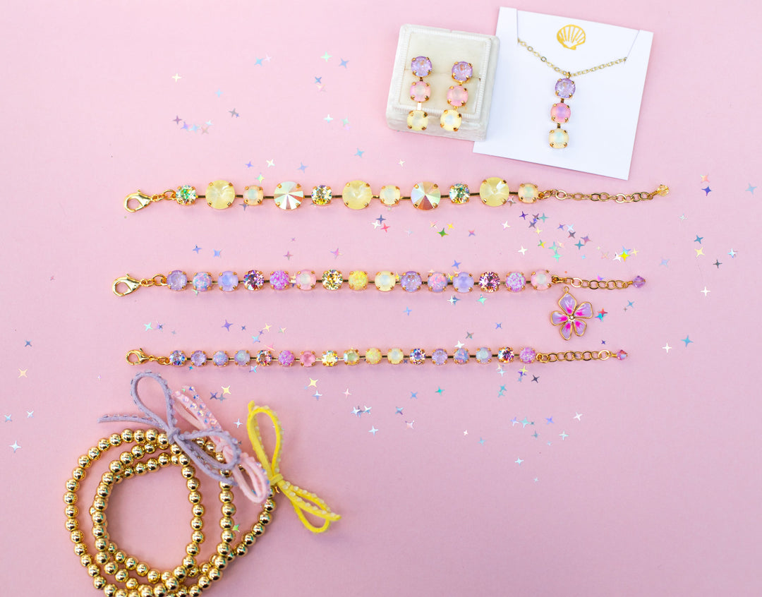 group photo of pink background with jewelry in pink, yellow and purple