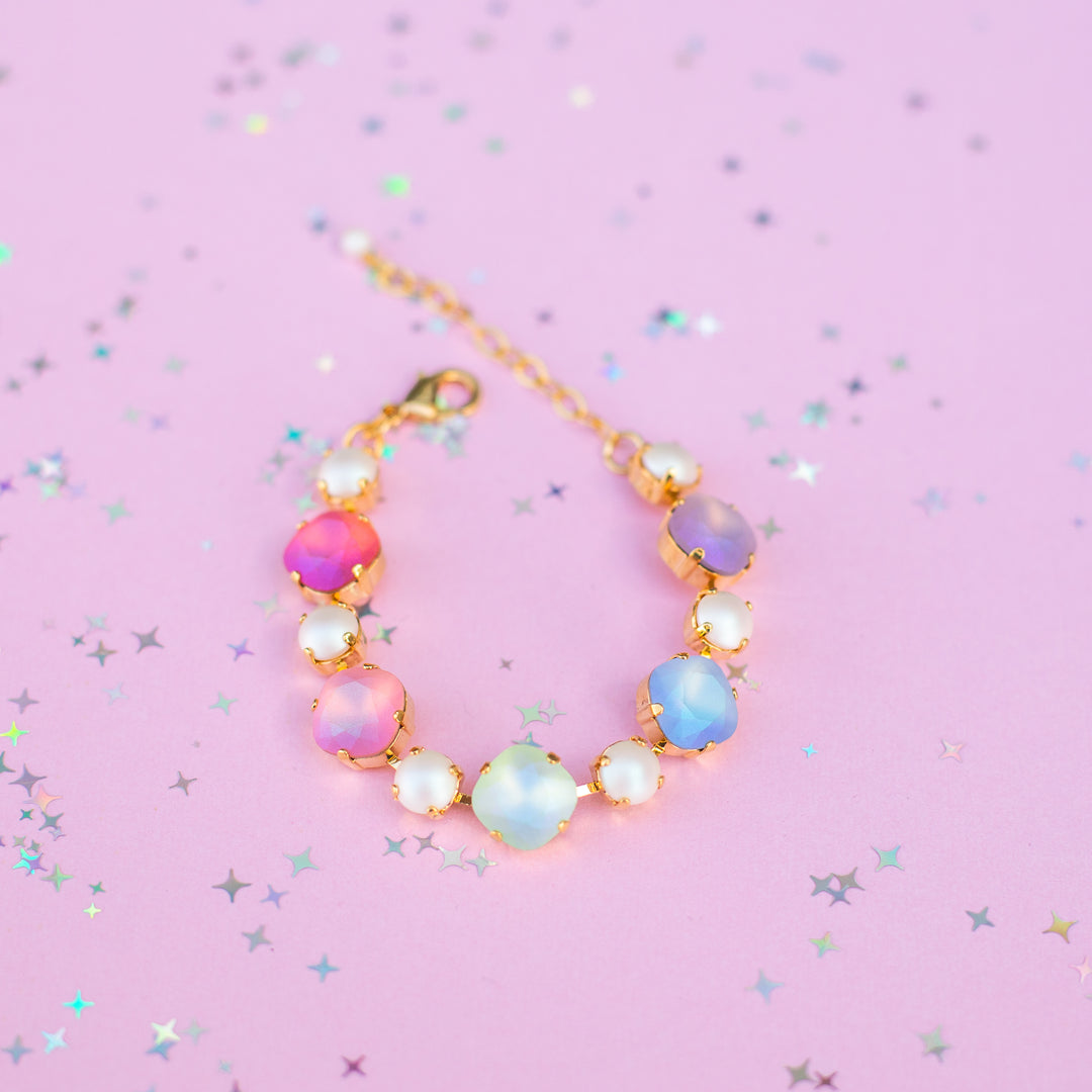 Multicolored beaded bracelet on a pink background with star and glitter patterns