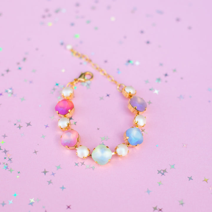 Multicolored beaded bracelet on a pink background with star and glitter patterns