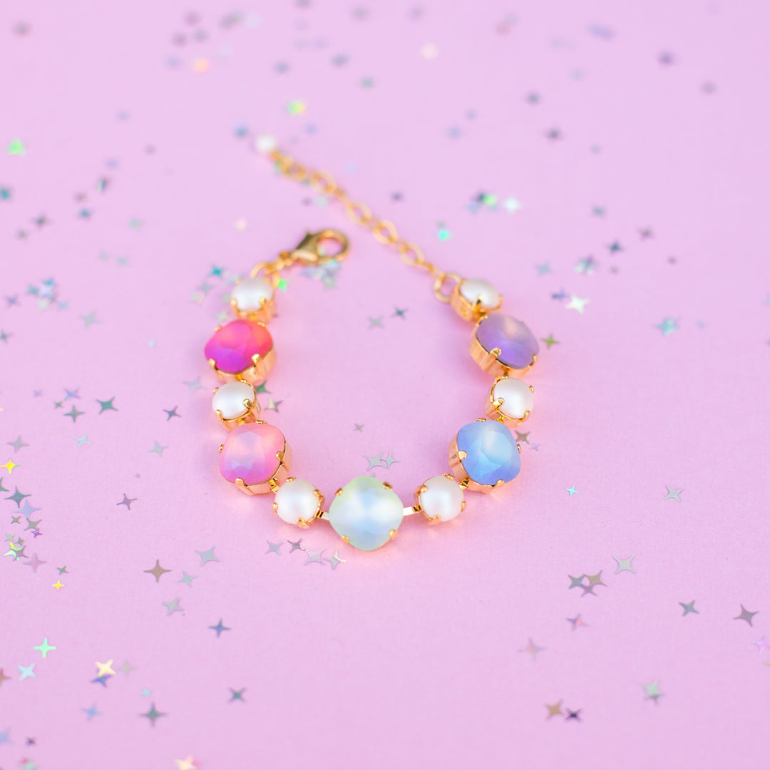 Multicolored beaded bracelet on a pink background with star-shaped glitter
