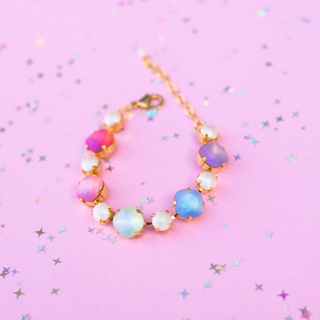 Colorful beaded bracelet on a pink background with star confetti