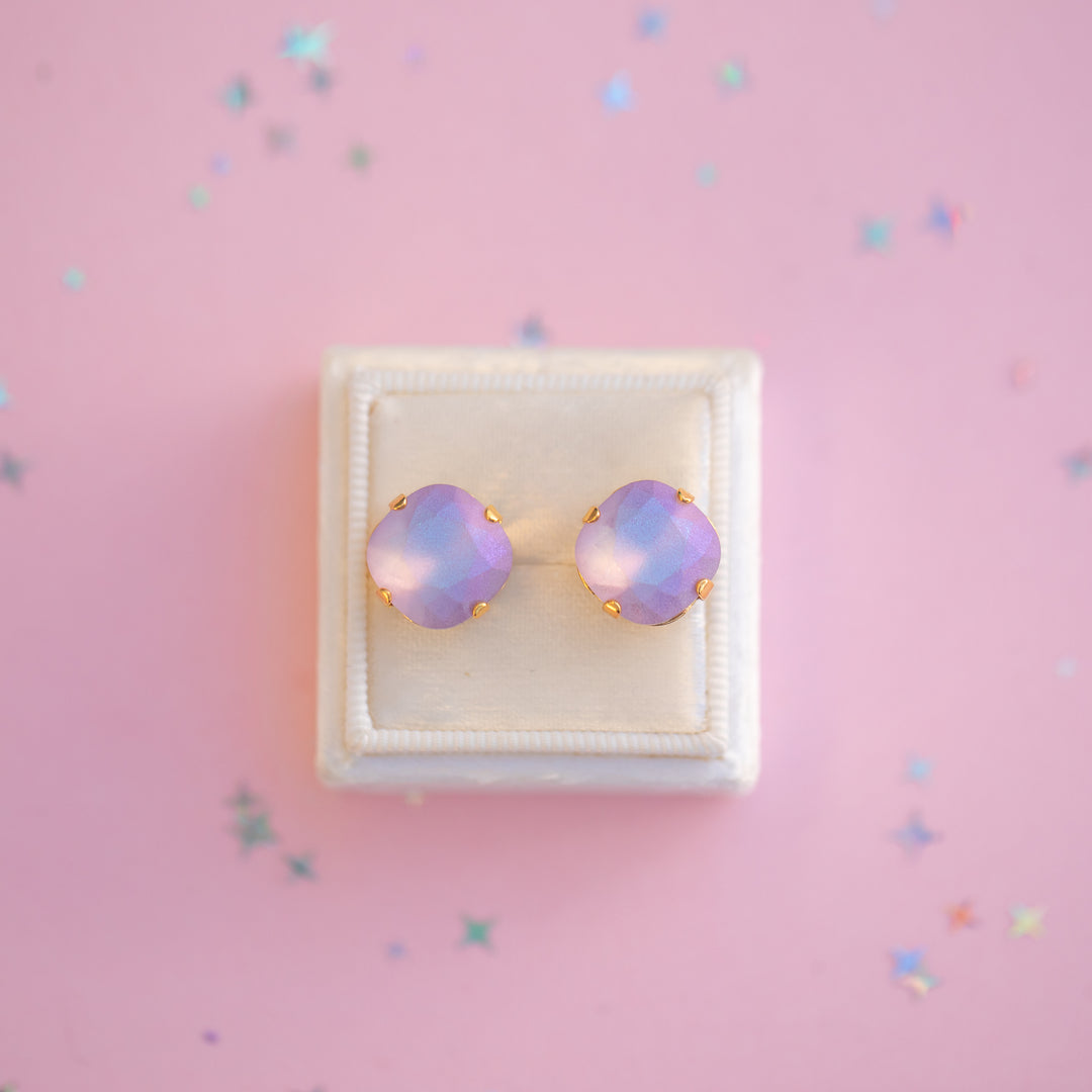 Pair of pink opal earrings in a white box on a pink background with confetti.
