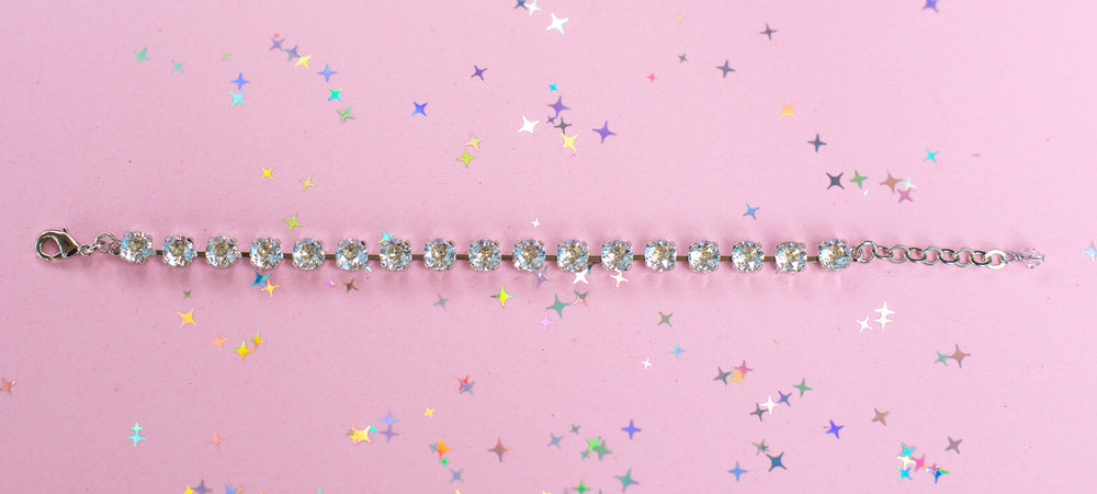 crystal bracelet shown in rhodium silver setting on a pink background