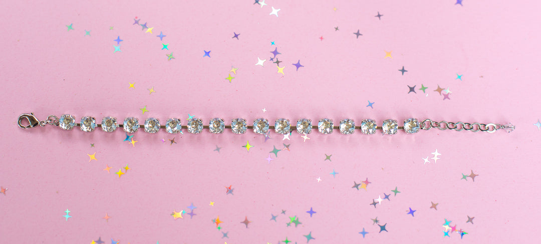crystal bracelet shown in rhodium silver setting on a pink background