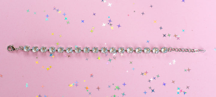 crystal bracelet shown in rhodium silver setting on a pink background