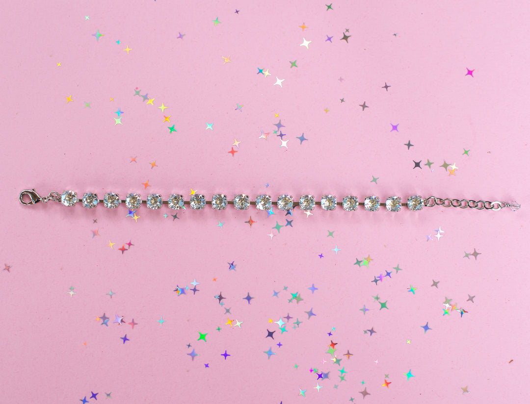 crystal bracelet shown in rhodium silver setting on a pink background