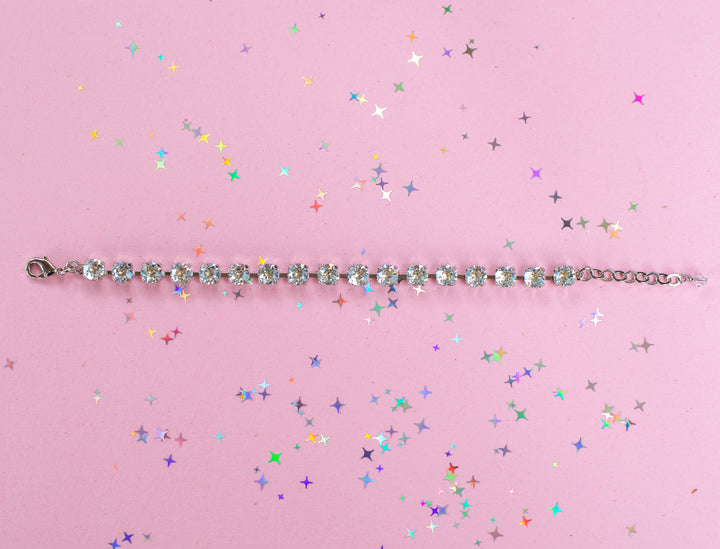 crystal bracelet shown in rhodium silver setting on a pink background