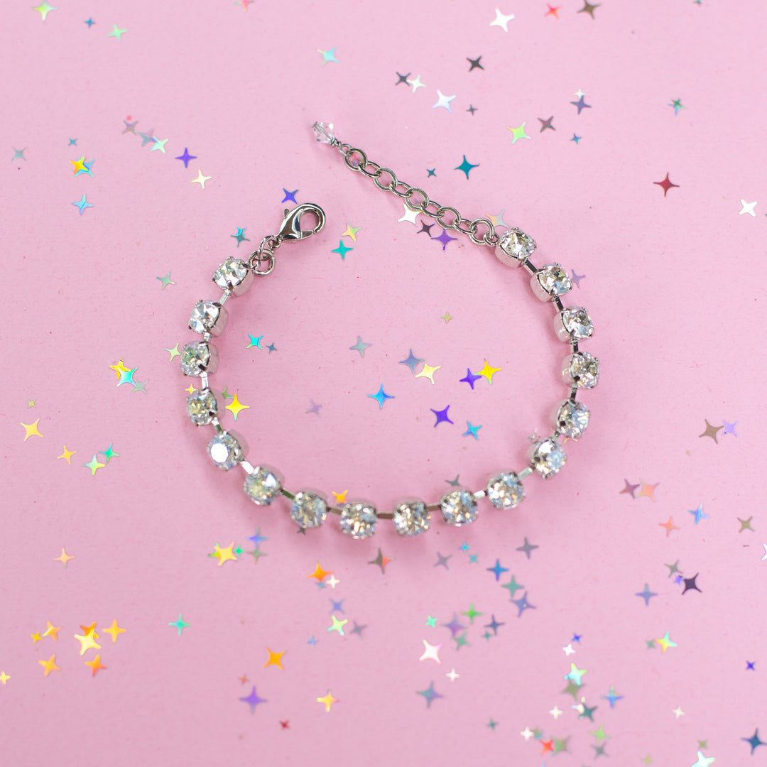 crystal bracelet shown in rhodium silver setting on a pink background