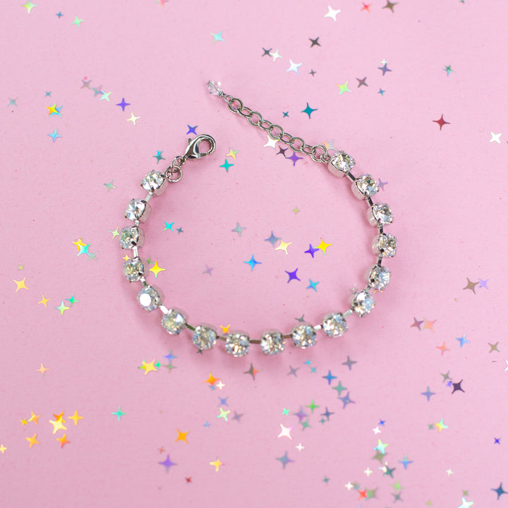 crystal bracelet shown in rhodium silver setting on a pink background