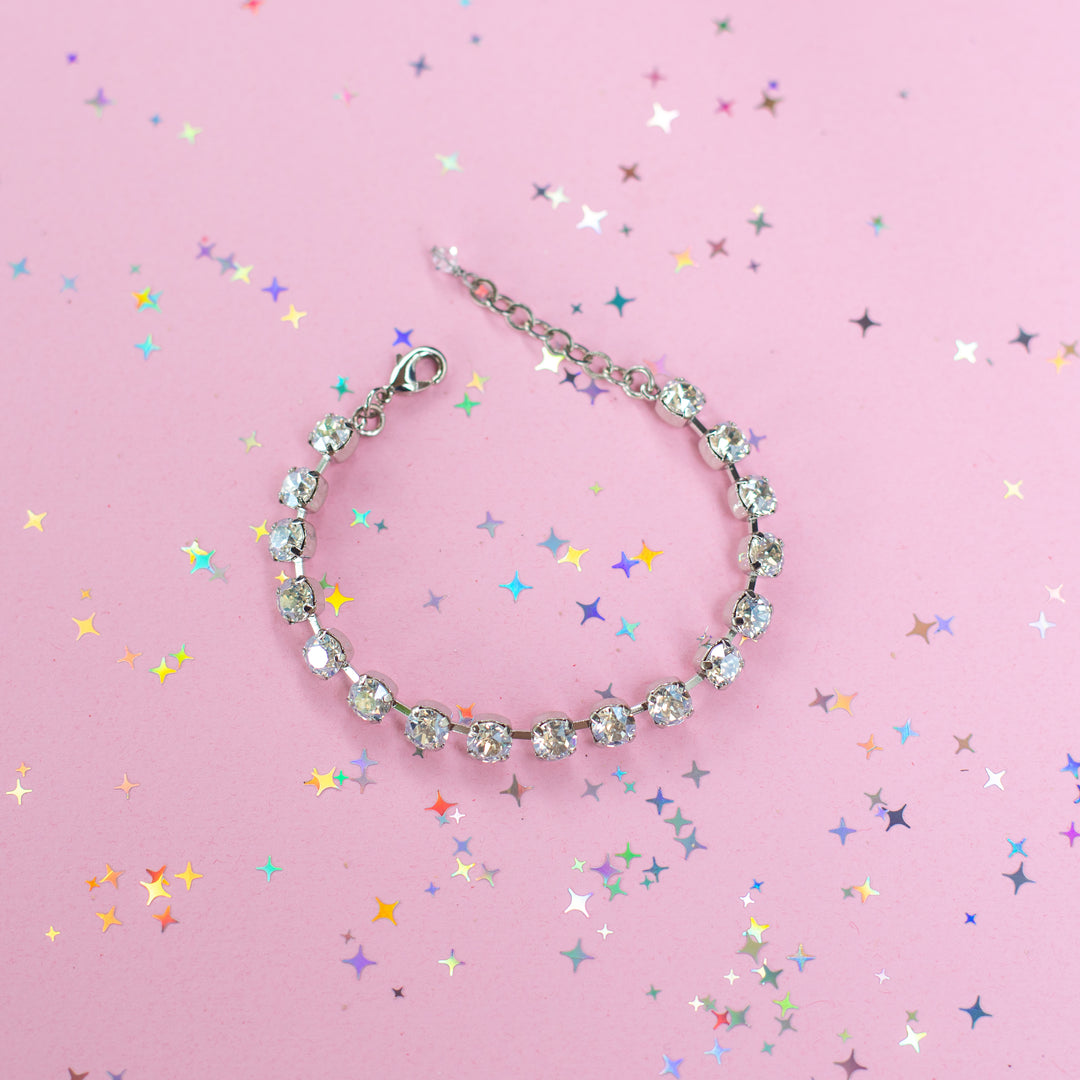 crystal bracelet shown in rhodium silver setting on a pink background