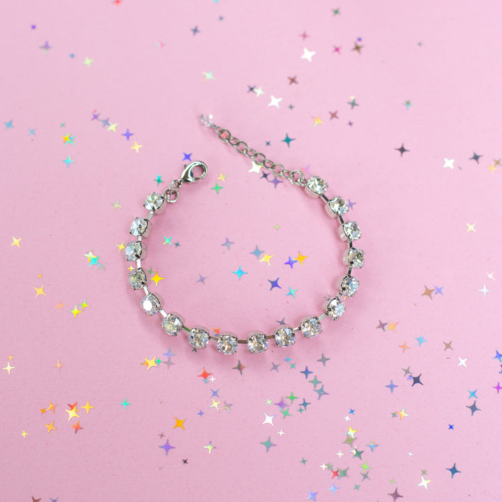 crystal bracelet shown in rhodium silver setting on a pink background