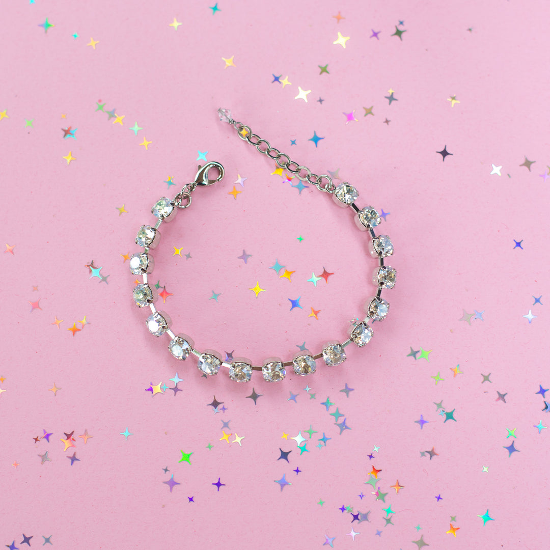 crystal bracelet shown in rhodium silver setting on a pink background