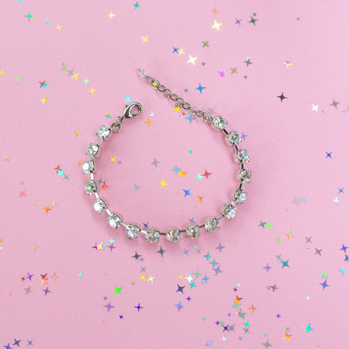 crystal bracelet shown in rhodium silver setting on a pink background