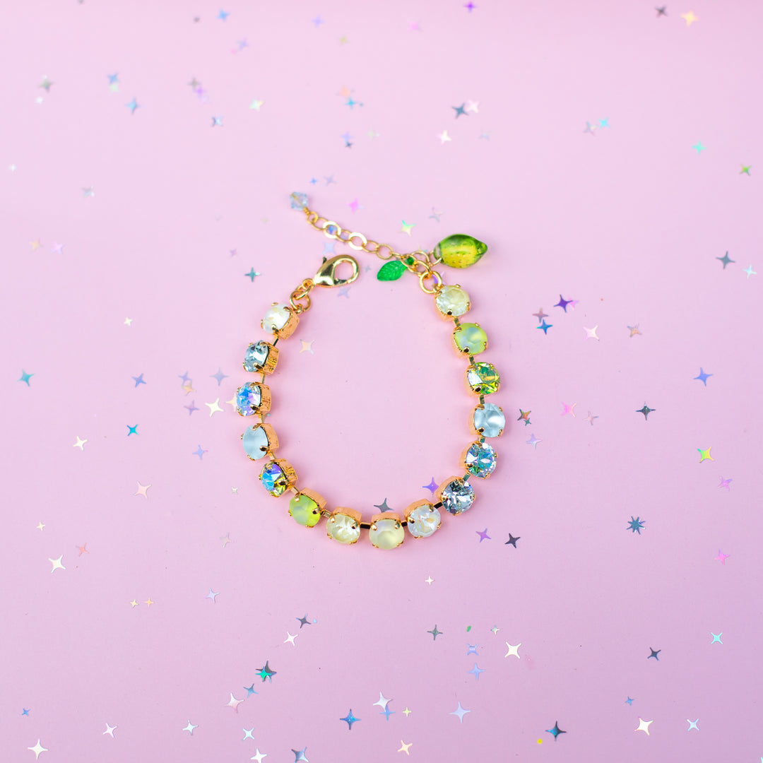 Multicolored beaded bracelet on a pink background with star-shaped confetti