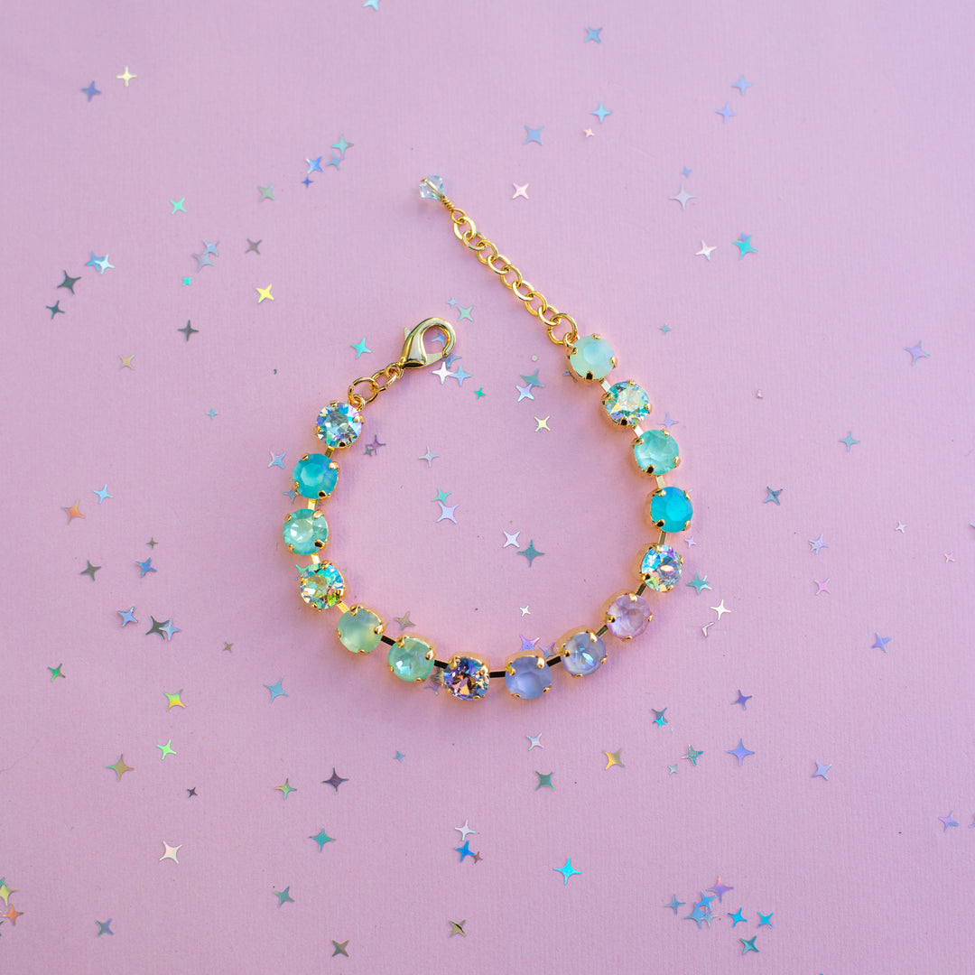 Bracelet with colorful beads on a pink background with star-shaped confetti