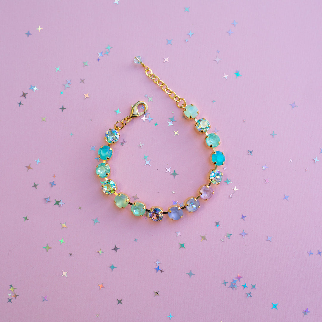 Bracelet with colorful beads on a pink background with star-shaped confetti