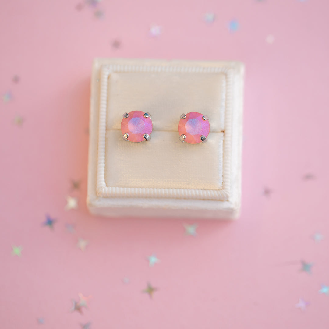 Pink opal stud earrings in a white box on a pink background