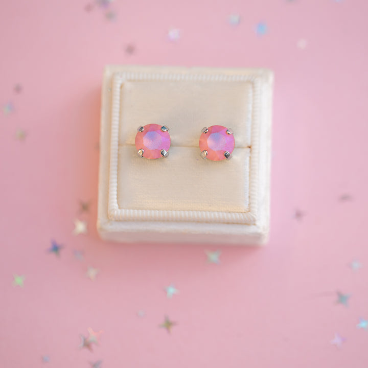 Pink opal stud earrings in a white box on a pink background