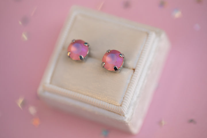 Pink opal stud earrings on a white box with a pink background