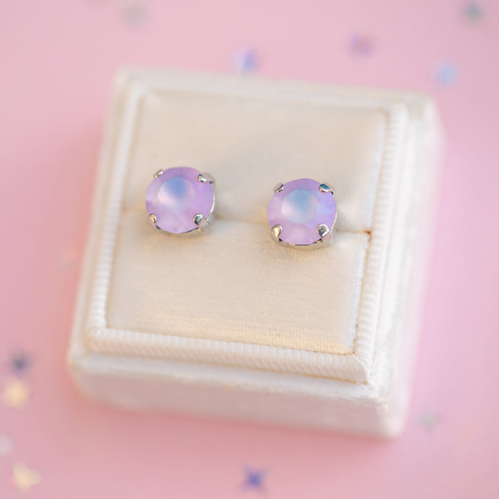 Pink stud earrings in a jewelry box on a pink background