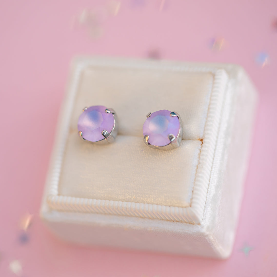 Pink opal stud earrings in a jewelry box on a pink background