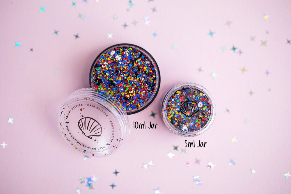 Two jars of colorful glitter on a pink background with star shapes.