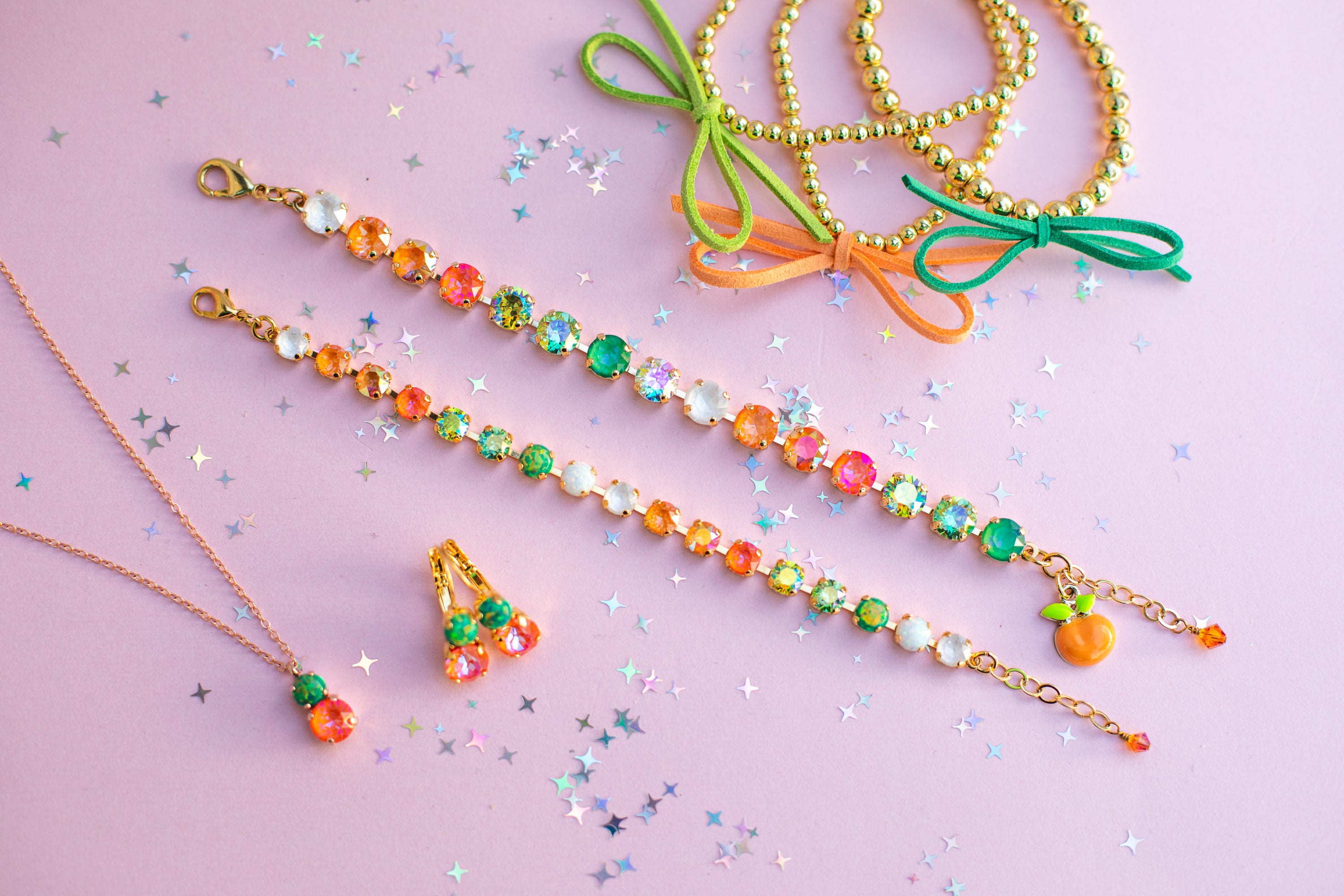 Colorful beaded necklaces with green bows on a pink background