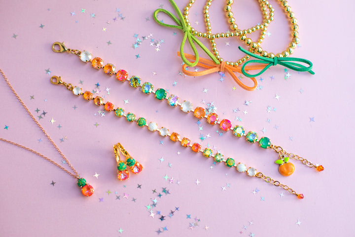 Colorful beaded necklaces with green bows on a pink background