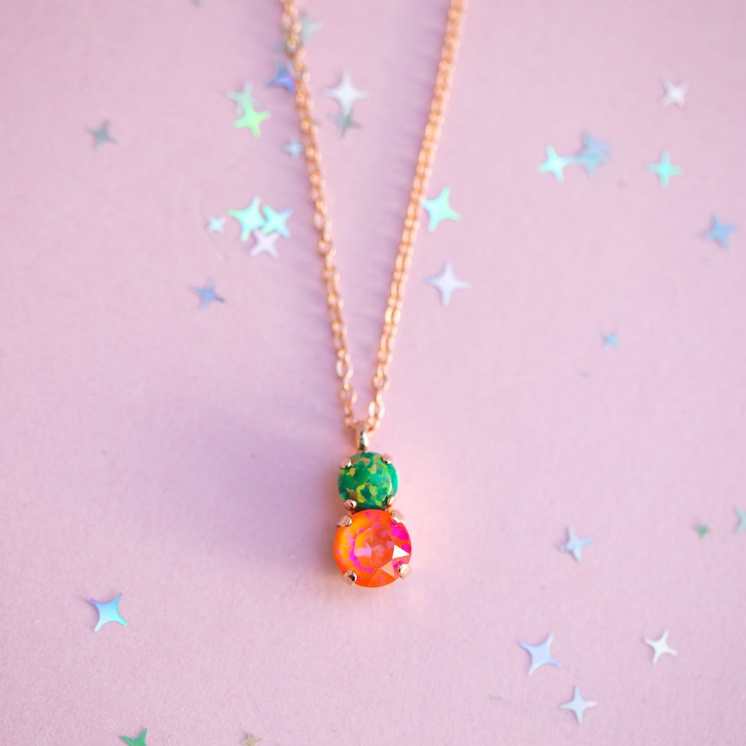 Necklace with colorful beads on a pink background with star shapes