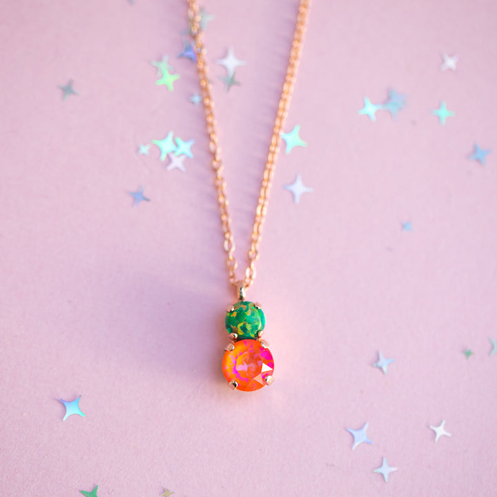 Necklace with colorful beads on a pink background with star shapes