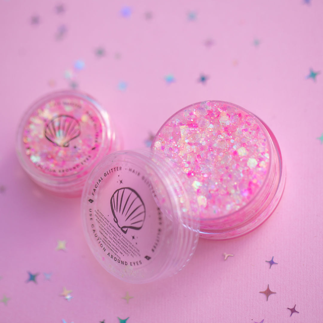 Pink glitter jar with a shell design on a pink background