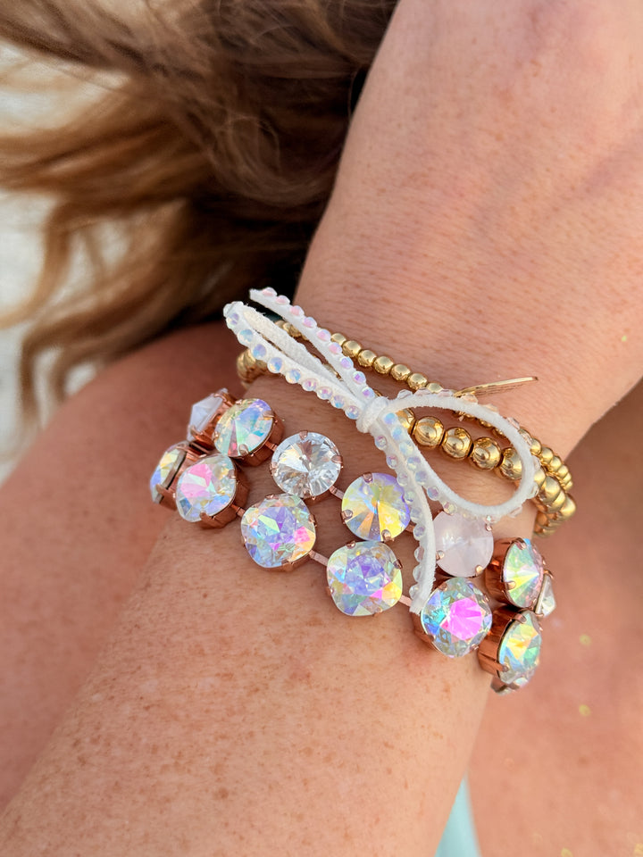 Close-up of a wrist wearing multiple beaded bracelets with iridescent beads.