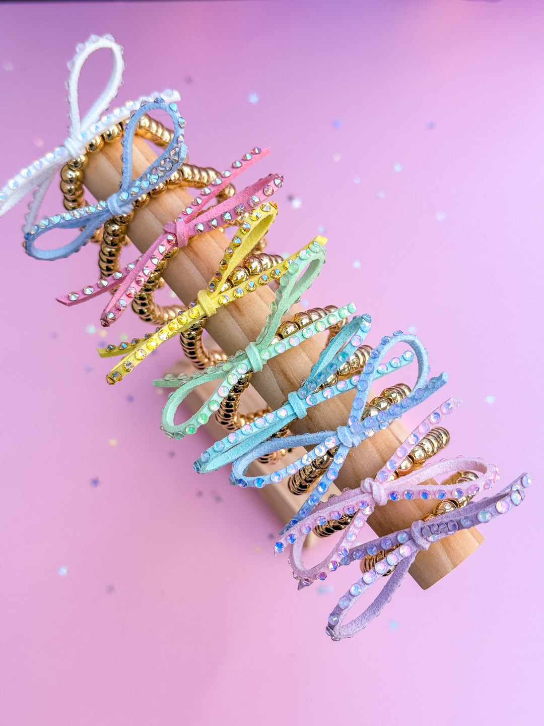 Pastel-colored bow bracelets on a pink background