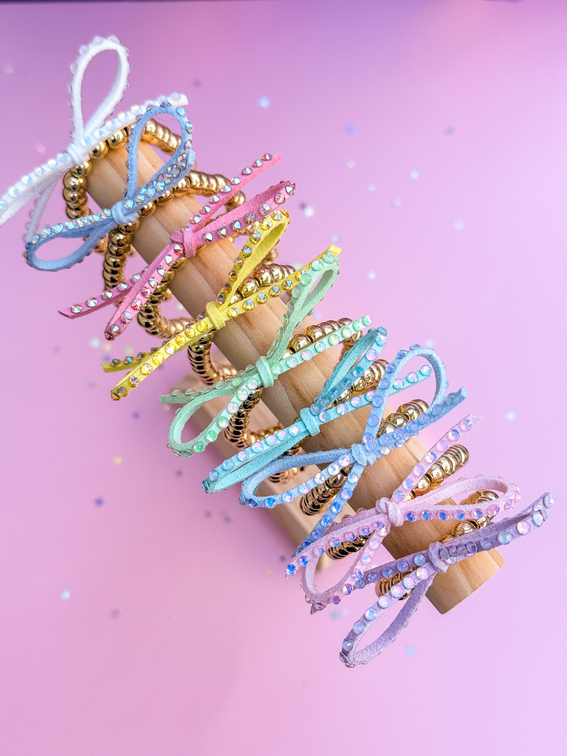 Pastel-colored bow bracelets on a pink background