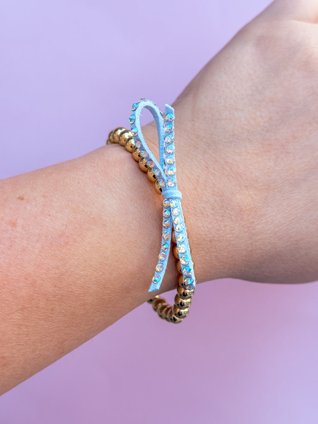 bracelet on a wrist against a purple background