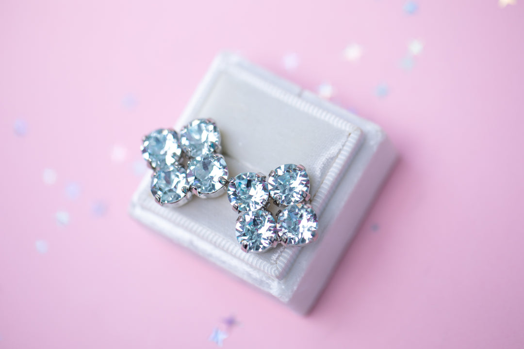 Pair of crystal earrings on a white box with a pink background