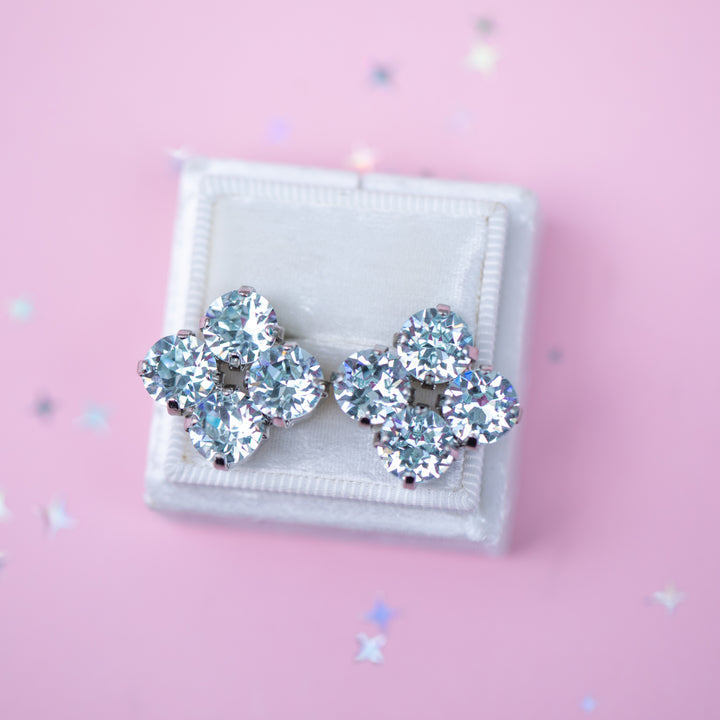 Pair of silver earrings on a pink background
