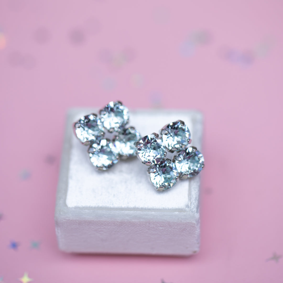 Pair of earrings on a white box with a pink background