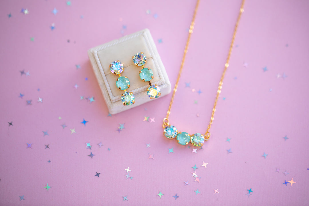 Jewelry set with earrings and necklace on a pink background