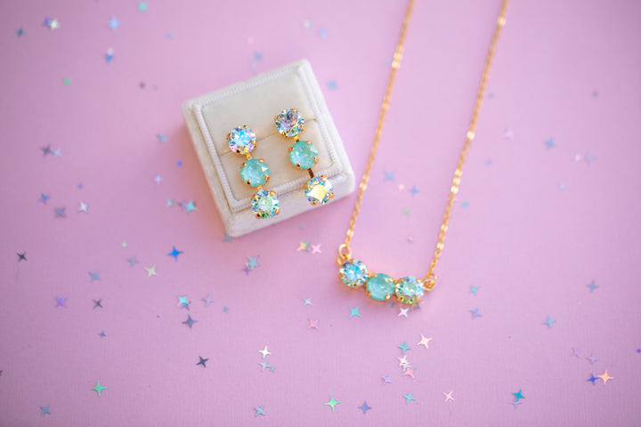 Jewelry set with earrings and necklace on a pink background