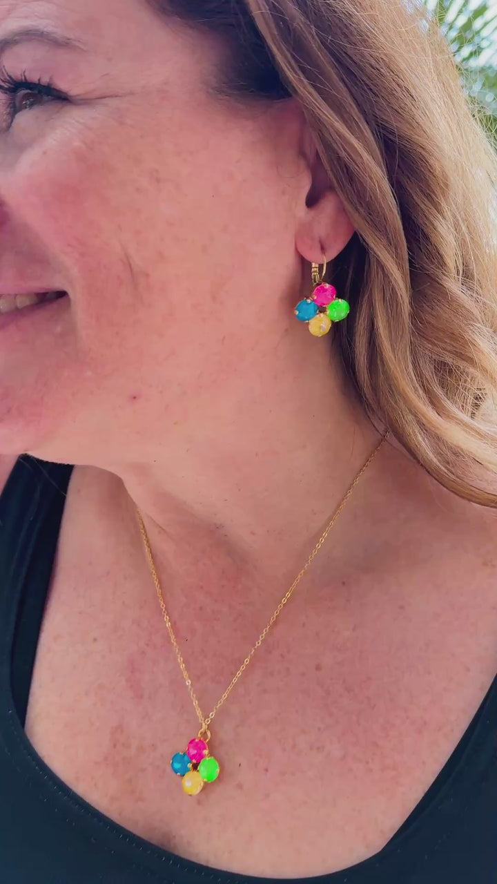 video of details of the clover earrings, necklace and neon green bracelets