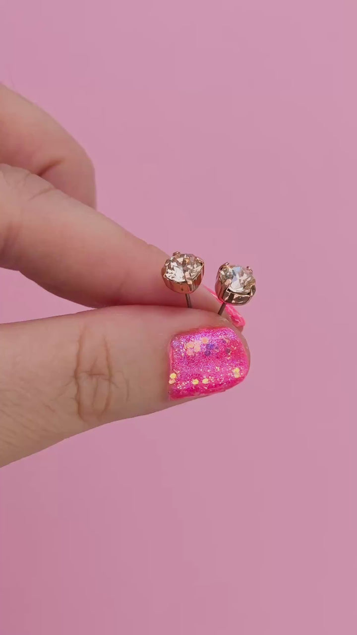 a round pair of Silk crystal studs in fingers to show size
