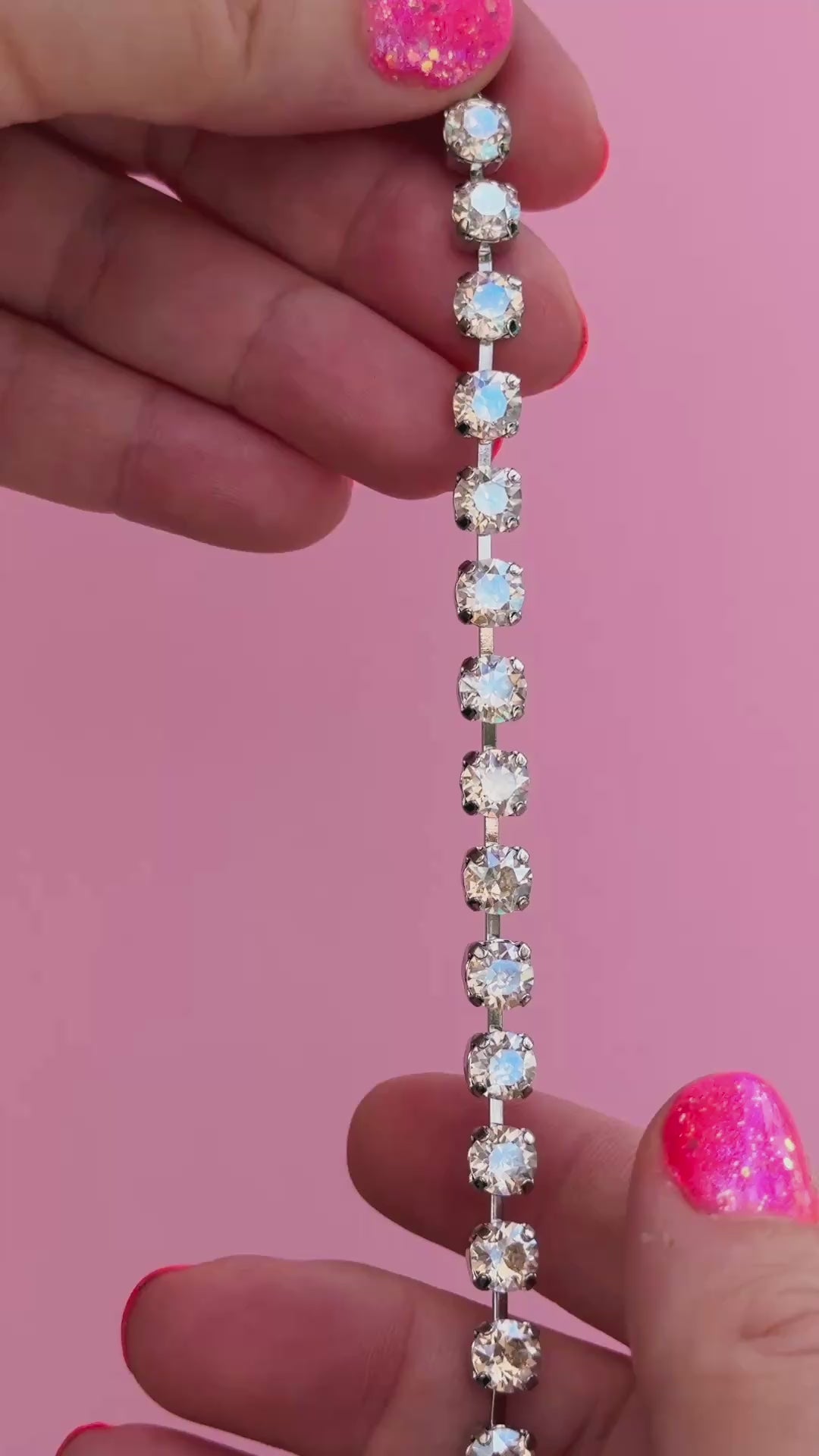 crystal bracelet shown in rhodium silver setting on a pink background