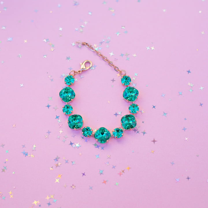 Bracelet with green gemstones on a purple background