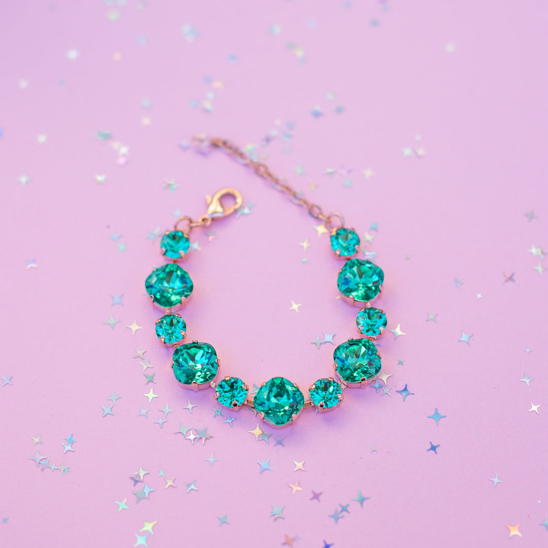 Turquoise necklace on a purple background with star-shaped confetti